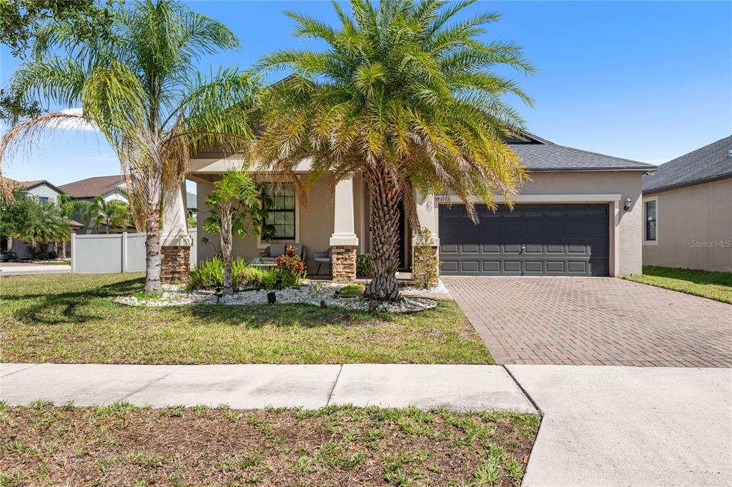 a view of a house with a yard and palm trees