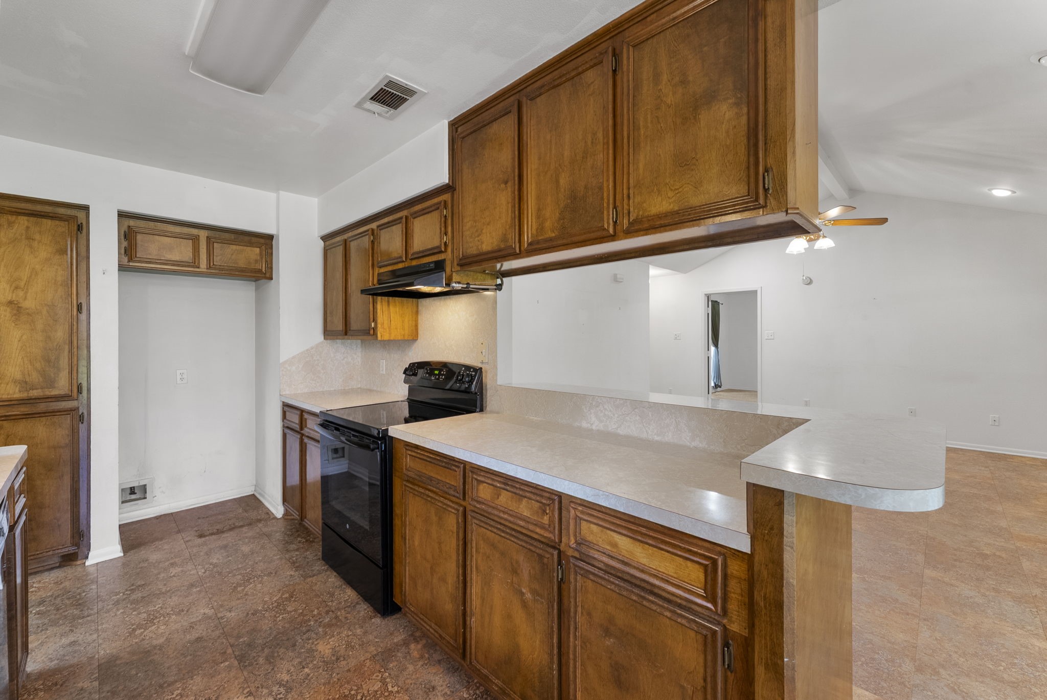 202 Sunset Boulevard Conroe, TX 77303 - Photo 17 of 50 This inviting kitchen boasts warm wood cabinetry, sleek countertops, and modern appliances, seamlessly blending into a spacious open-plan area perfect for entertaining.