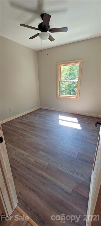 6722 Old Clyde Road Canton, NC 28716 - Photo 26 of 27 an empty room with wooden floor chandelier and windows