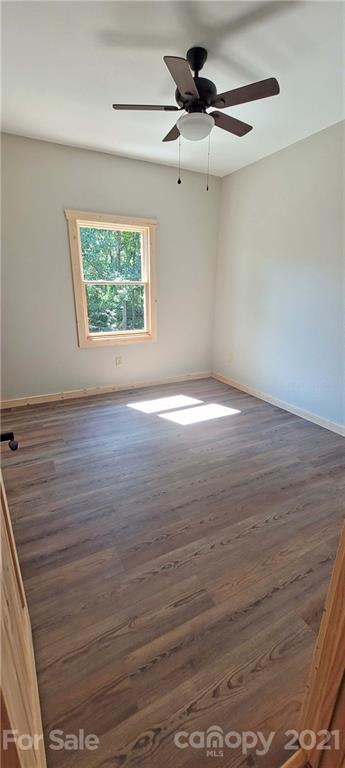 6722 Old Clyde Road Canton, NC 28716 - Photo 27 of 27 an empty room with wooden floor chandelier fan and windows