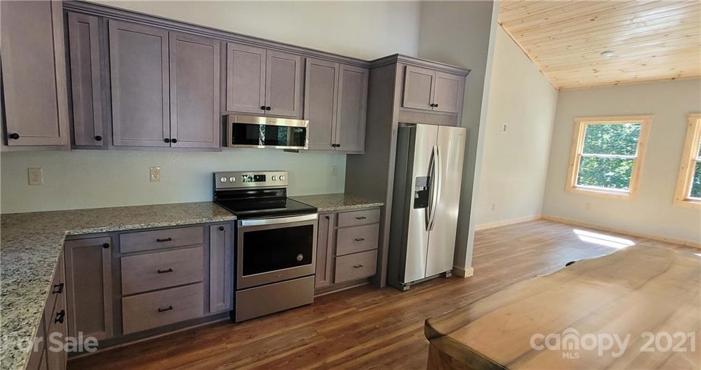 6722 Old Clyde Road Canton, NC 28716 - Photo 10 of 27 a kitchen with granite countertop wooden cabinets and stainless steel appliances