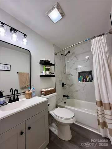 a bathroom with a bathtub sink mirror vanity and toilet