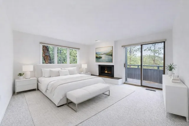 an empty room with wooden floor fireplace and windows