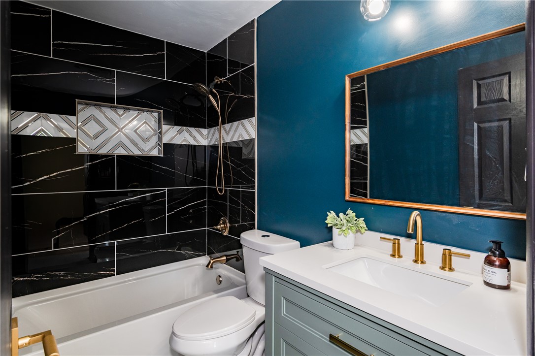 5240 Haverfield Road Dayton, OH 45432 - Photo 39 of 58 This sleek bathroom features a modern vanity with elegant fixtures and striking tiled shower.