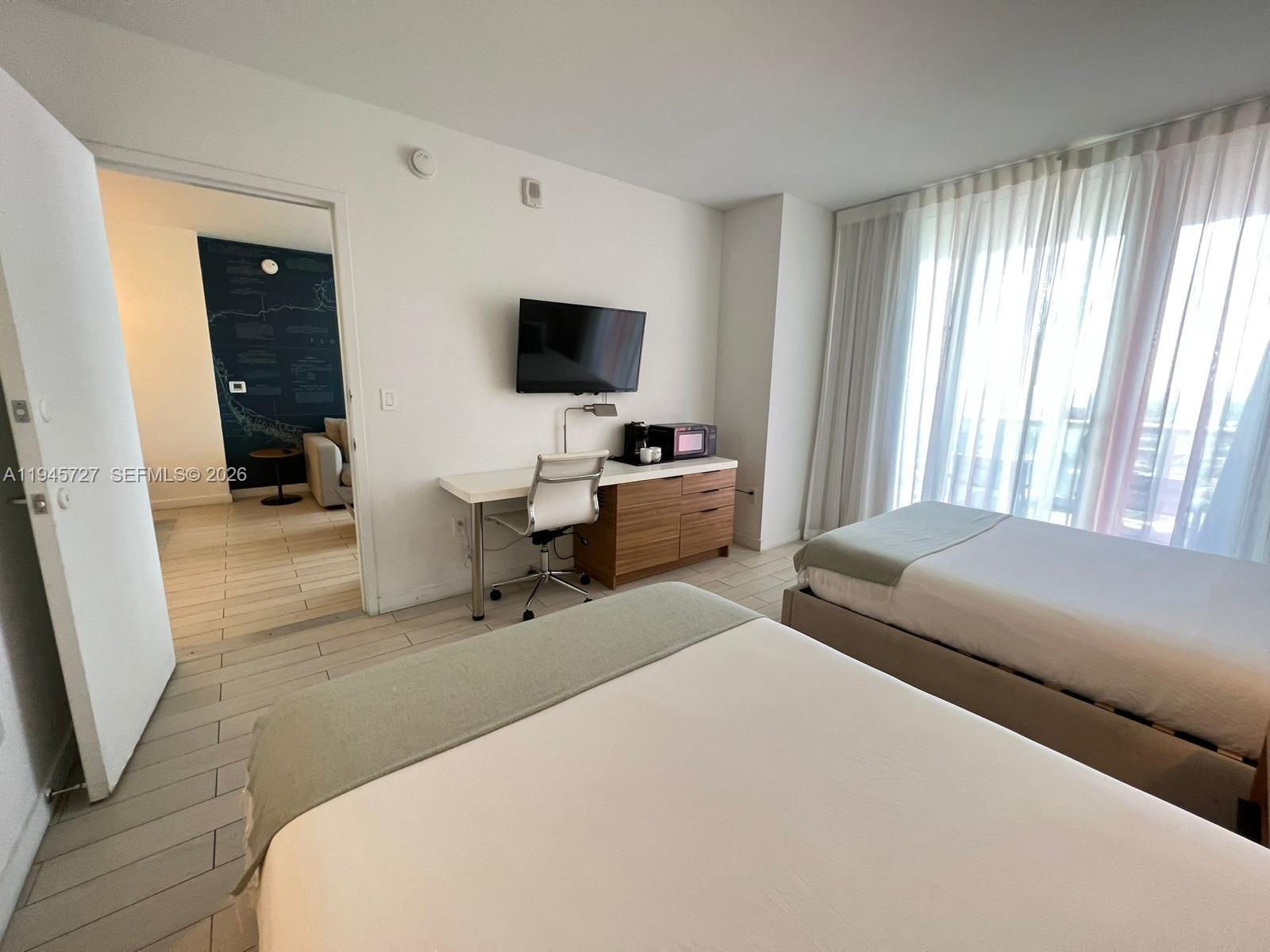 2602 East Hallandale Beach Boulevard, Unit R2810 Hallandale Beach, FL 33009 - Photo 15 of 31 a bedroom with a bed and a flat screen tv