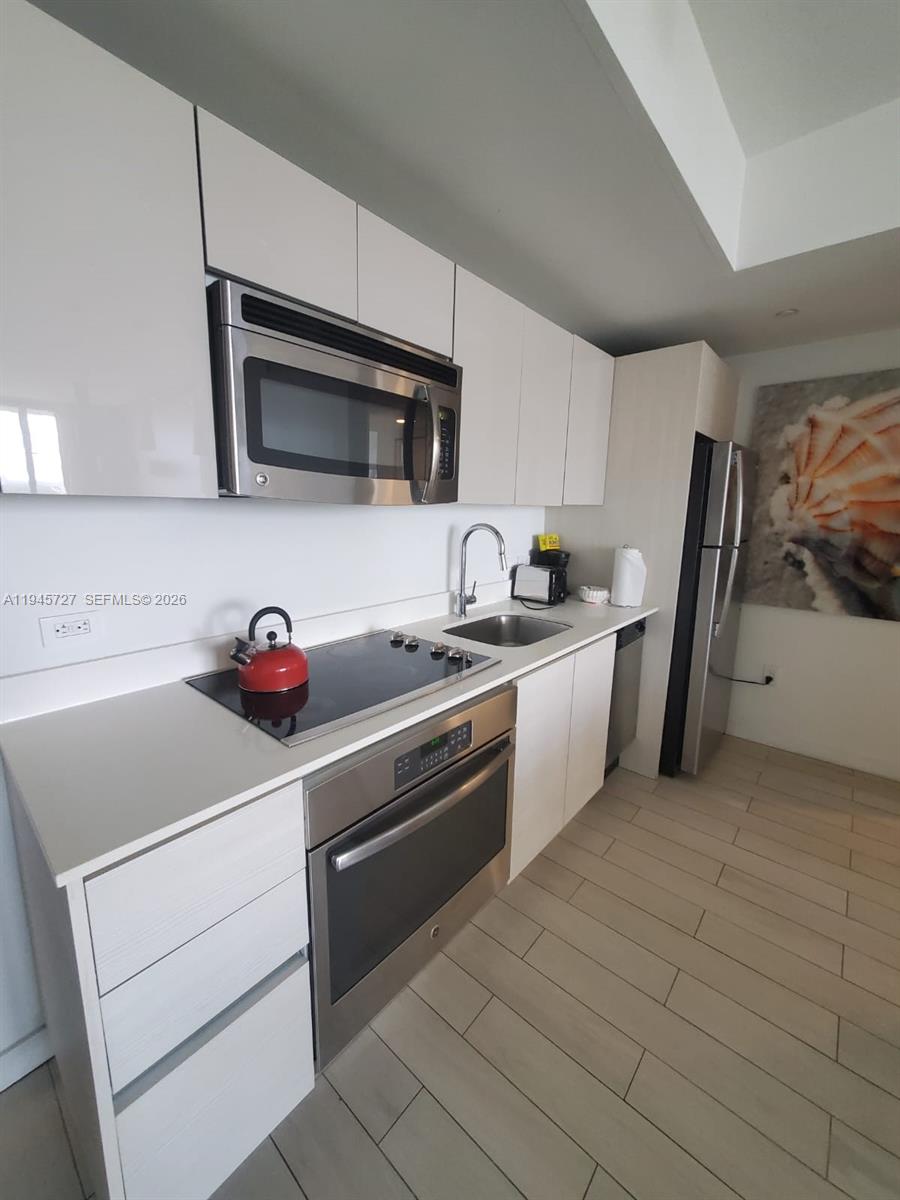 2602 East Hallandale Beach Boulevard, Unit R2810 Hallandale Beach, FL 33009 - Photo 8 of 31 a kitchen with stainless steel appliances granite countertop a sink and a stove