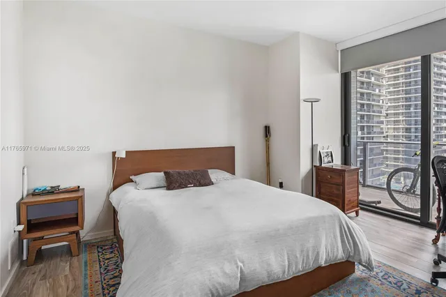 a bedroom with a bed and a dresser with wooden floor