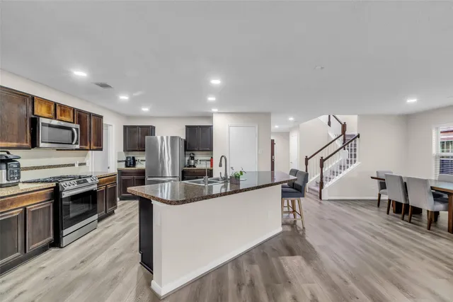 a kitchen with stainless steel appliances kitchen island granite countertop a stove and a sink