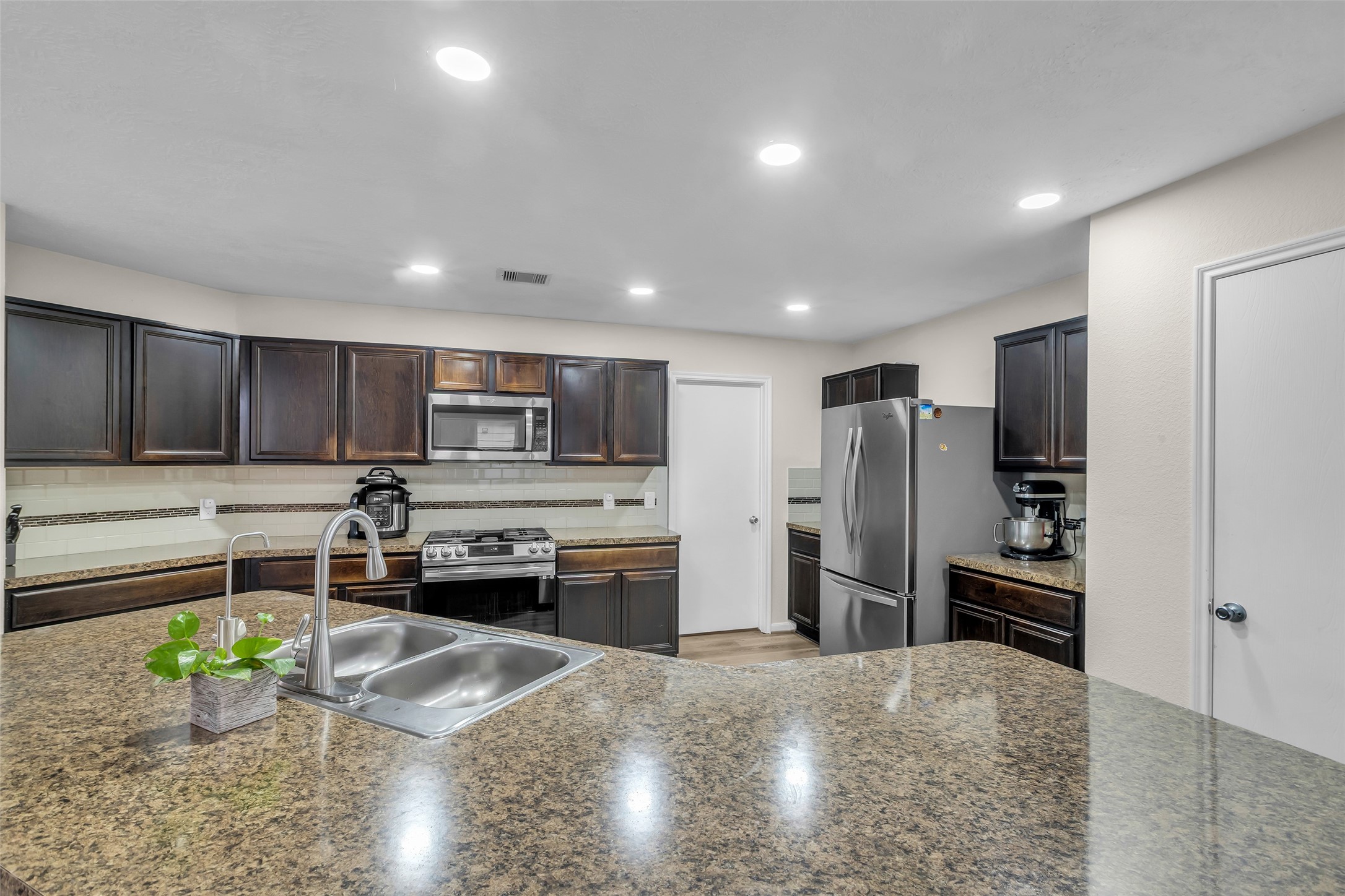 12626 Mint Field Houston, TX 77066 - Photo 7 of 26 a kitchen with stainless steel appliances granite countertop a refrigerator and a stove top oven