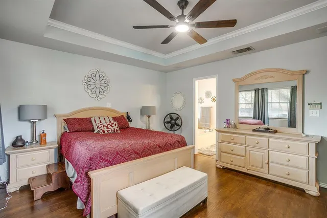 a bedroom with a large bed and a chandelier