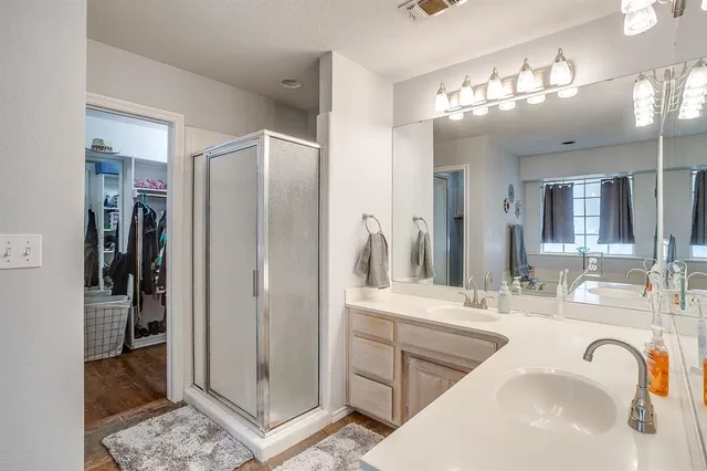 a bathroom with a double vanity sink mirror and shower