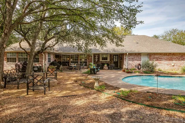 a view of a patio with table and chairs potted plants and floor to ceiling window