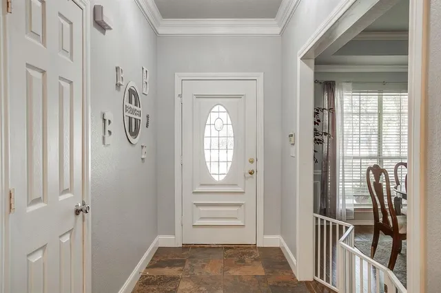 a view of a hallway to a livingroom with wooden floor and windows