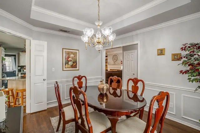 a view of a dining room with furniture wooden floor and chandelier