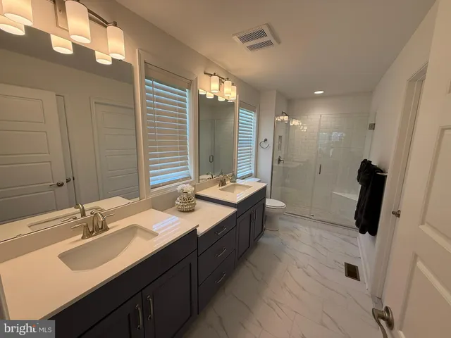 a bathroom with a double vanity sink a mirror and a shower