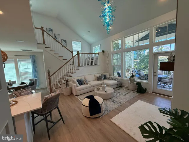a living room with furniture large window and wooden floor