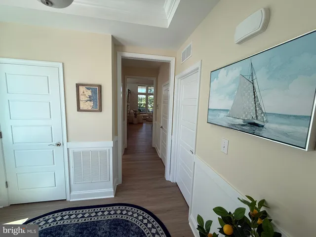 a view of a hallway with wooden floor and closet