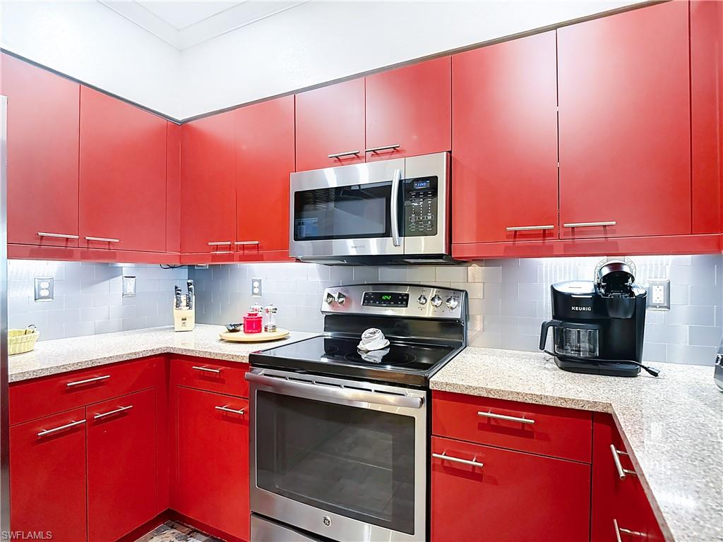 106 Siena Way, Unit 1508 Naples, FL 34119 - Photo 19 of 47 a kitchen with stainless steel appliances a microwave sink and cabinets