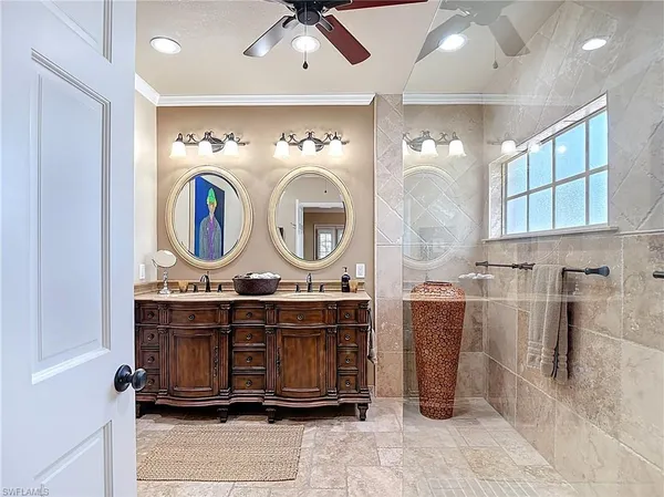 a bathroom with a granite countertop shower a sink and a window