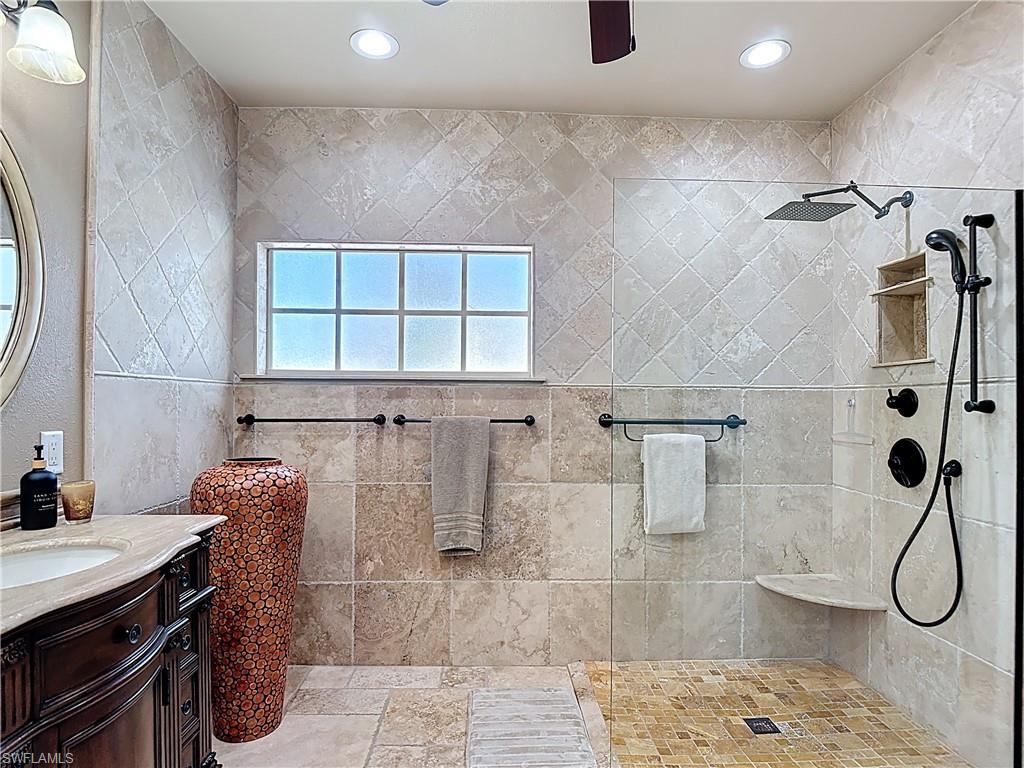 106 Siena Way, Unit 1508 Naples, FL 34119 - Photo 28 of 47 a bathroom with a granite countertop shower a sink and a window
