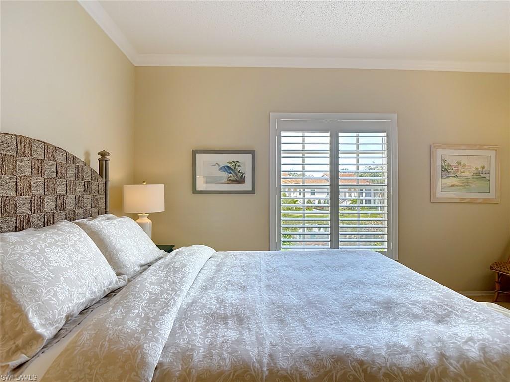 106 Siena Way, Unit 1508 Naples, FL 34119 - Photo 33 of 47 a bedroom with a large bed and a window