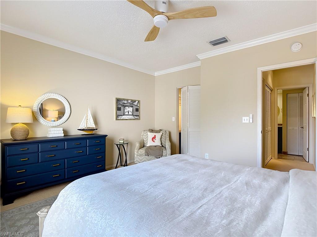 106 Siena Way, Unit 1508 Naples, FL 34119 - Photo 34 of 47 a bedroom with a bed and cabinets
