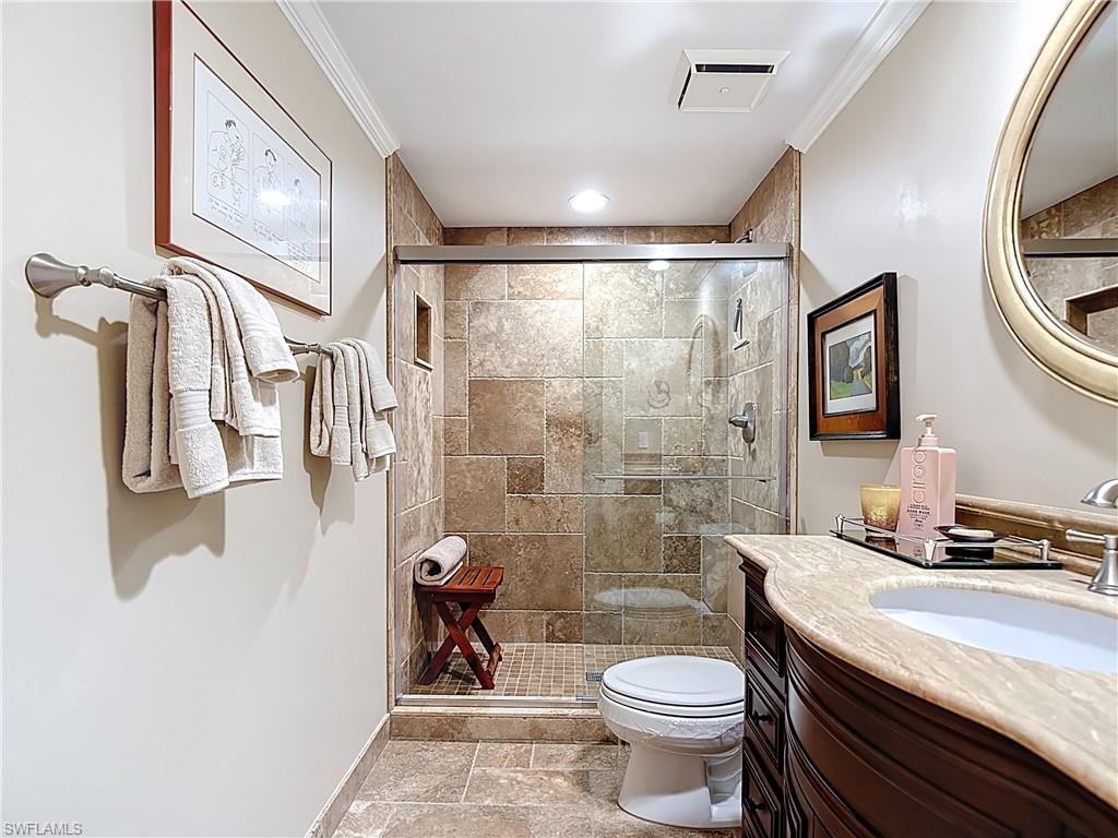 106 Siena Way, Unit 1508 Naples, FL 34119 - Photo 38 of 47 a bathroom with a granite countertop toilet a sink and a shower