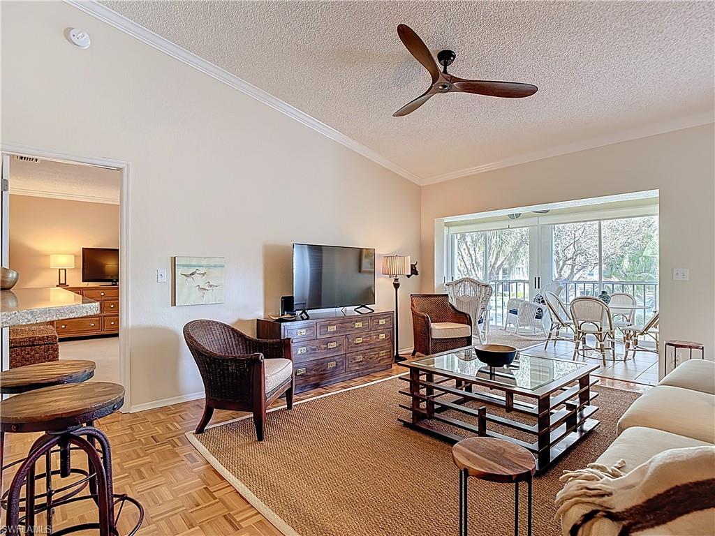106 Siena Way, Unit 1508 Naples, FL 34119 - Photo 8 of 47 a living room with furniture a flat screen tv and a large window
