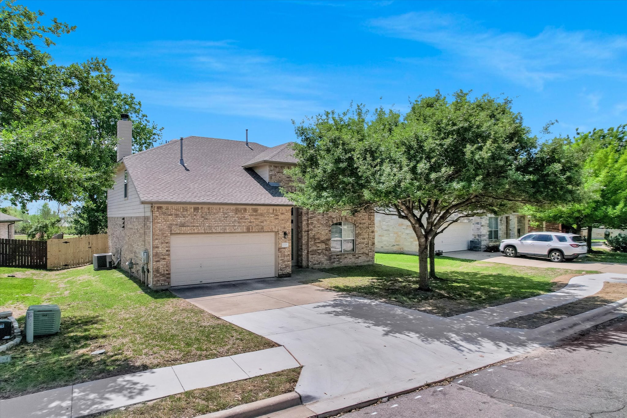 4029 Lake Edge Way Pflugerville, TX 78660 - Photo 32 of 35 View of front of house featuring an attached garage, driveway, brick siding, roof with shingles, and a chimney