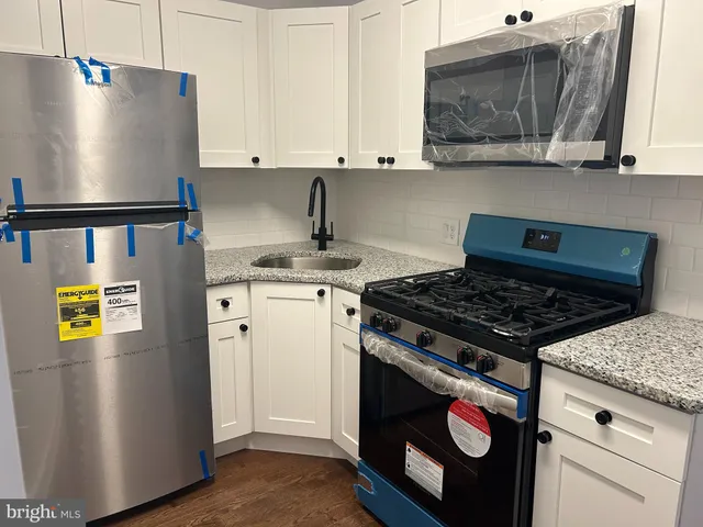 a kitchen with stainless steel appliances granite countertop a stove a refrigerator and a microwave