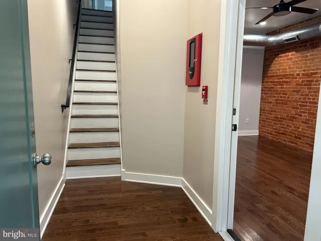 a view of a hallway with wooden floor and staircase