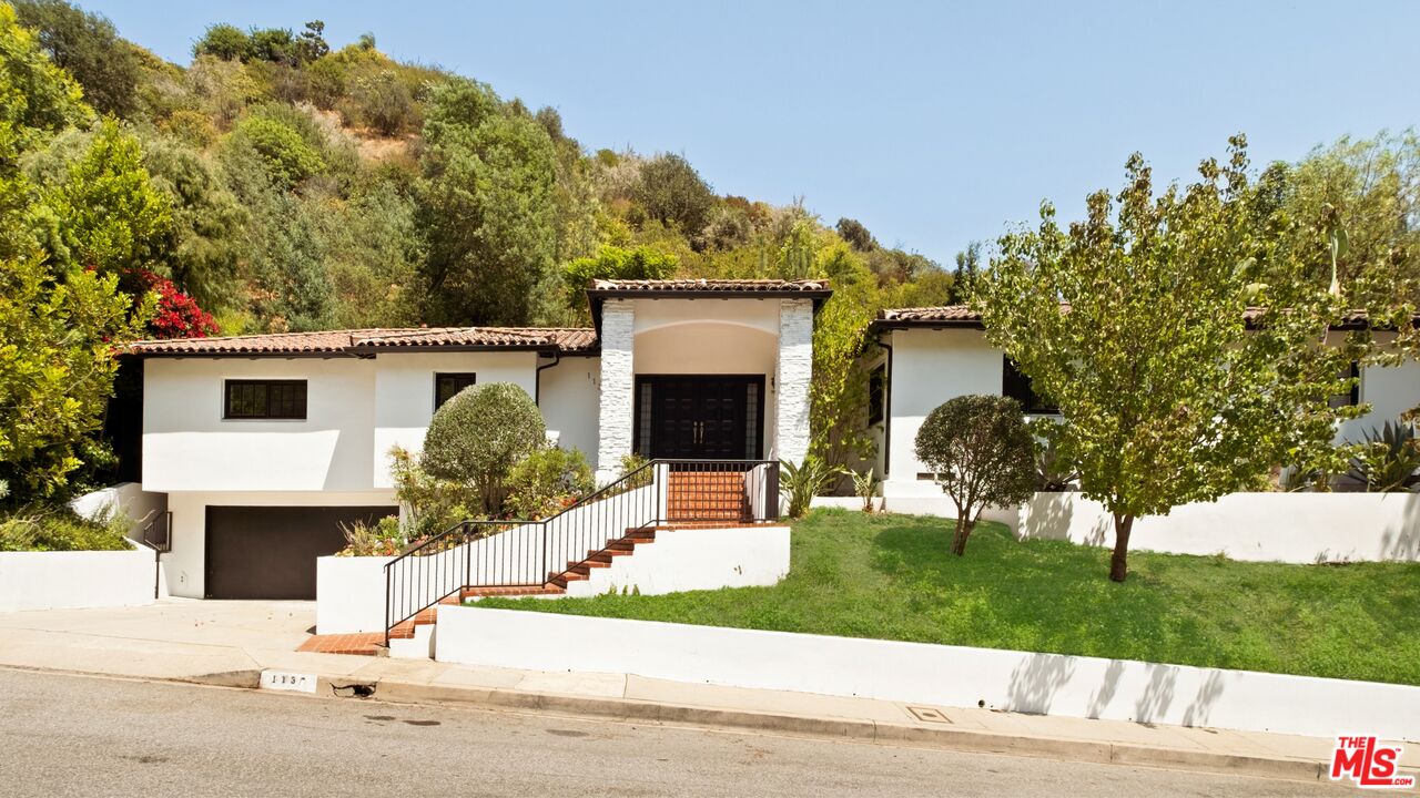 1132 Chantilly Road Los Angeles, CA 90077 - Photo 1 of 22 a front view of a house with a yard and garage