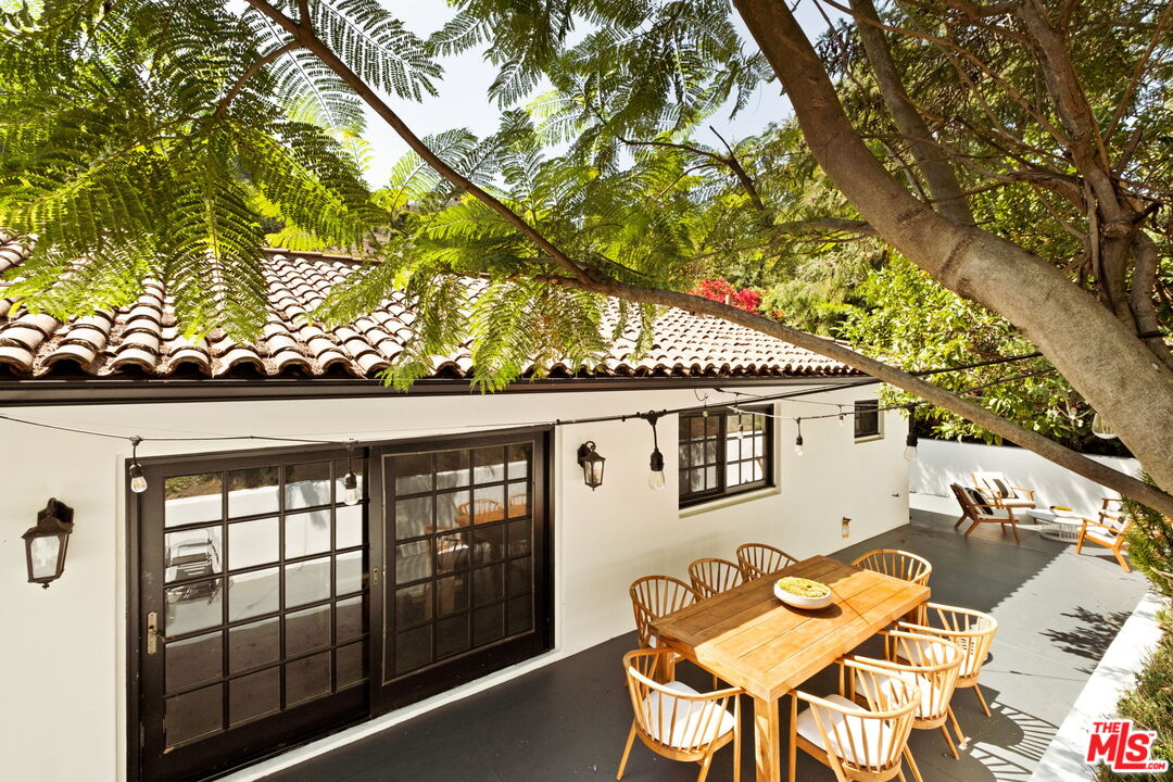 1132 Chantilly Road Los Angeles, CA 90077 - Photo 17 of 22 a backyard of a house with wooden table and chairs