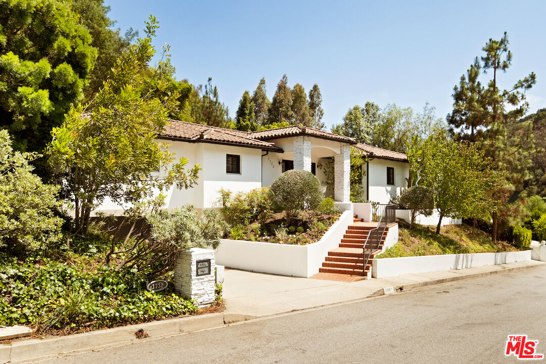 1132 Chantilly Road Los Angeles, CA 90077 - Photo 22 of 22 a view of a white house with a tree and flower garden