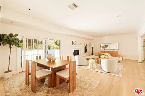a dining room with furniture and a floor to ceiling window