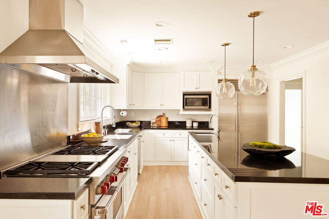 1132 Chantilly Road Los Angeles, CA 90077 - Photo 7 of 22 a kitchen with stainless steel appliances granite countertop a stove a sink and a refrigerator