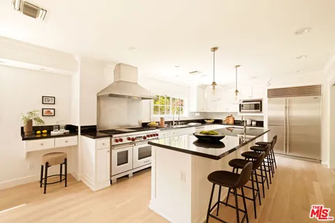 a kitchen with stainless steel appliances a stove a sink and a refrigerator