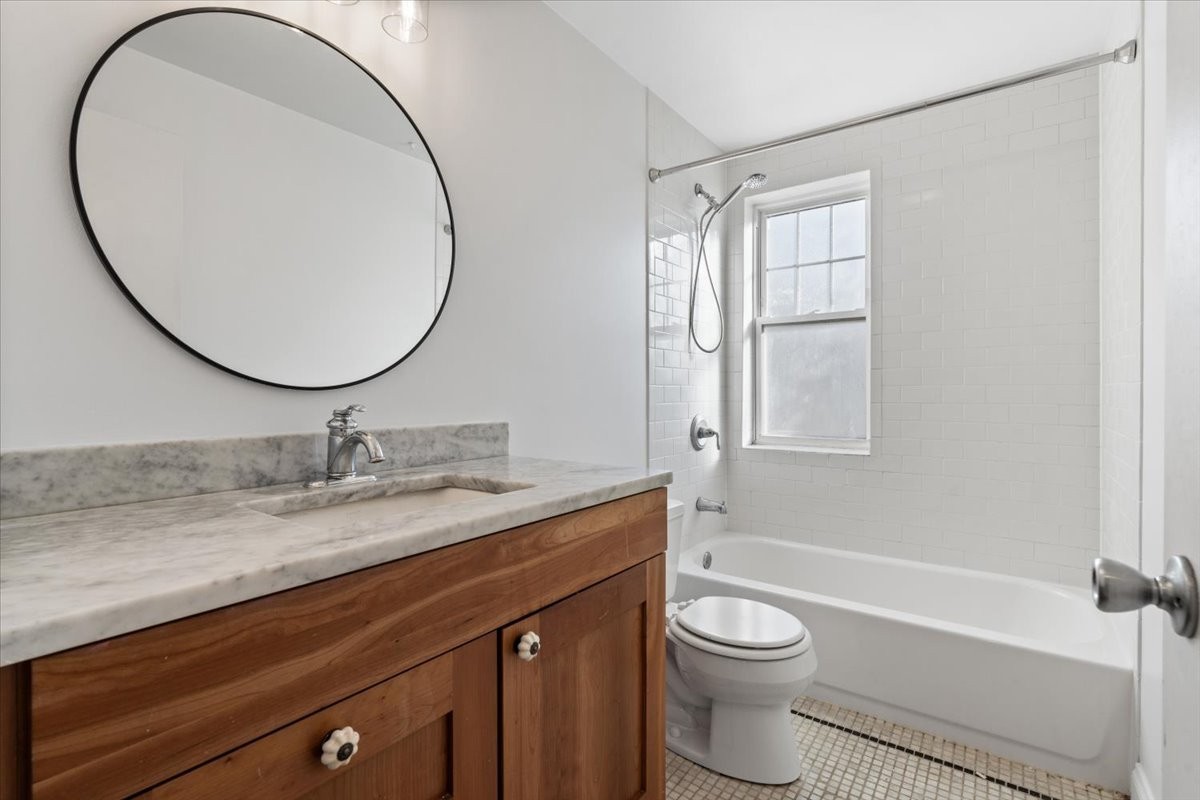 4420 North Ashland Avenue, Unit 3E Chicago, IL 60640 - Photo 11 of 15 a bathroom with a granite countertop toilet a sink and a mirror