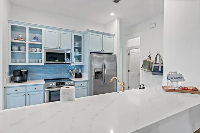 a kitchen with kitchen island a sink stainless steel appliances and cabinets