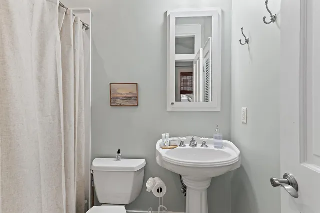 a bathroom with a sink mirror and toilet