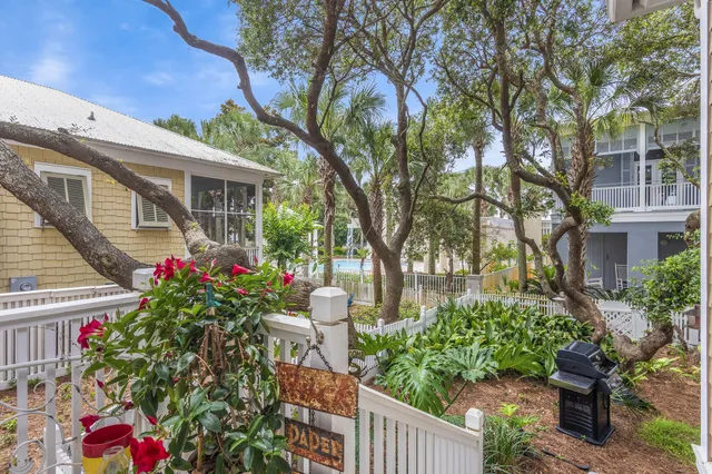 a house with lots of trees and flowers around