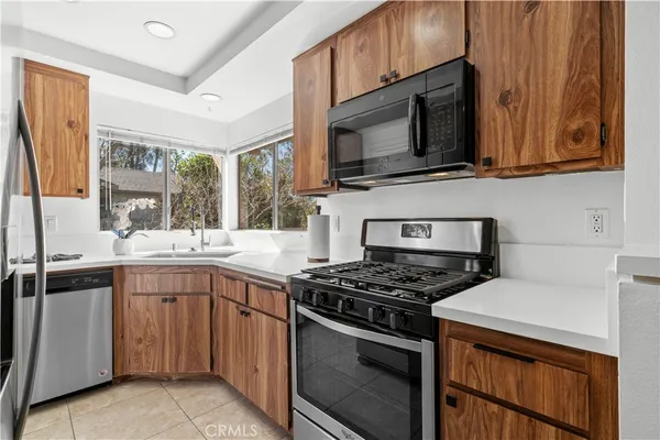 a kitchen with stainless steel appliances granite countertop a stove microwave and sink