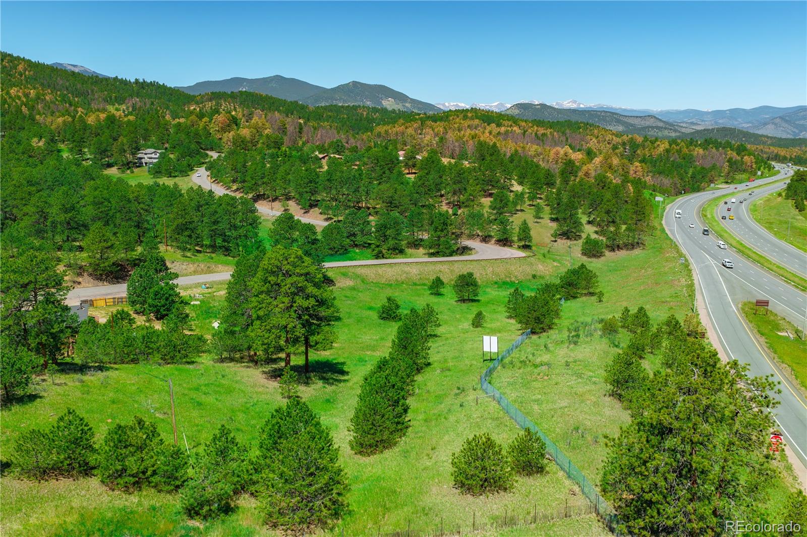 29793 Ruby Ranch Road Evergreen, CO 80439 - Photo 13 of 28 a view of a lush green field with a mountain in the background