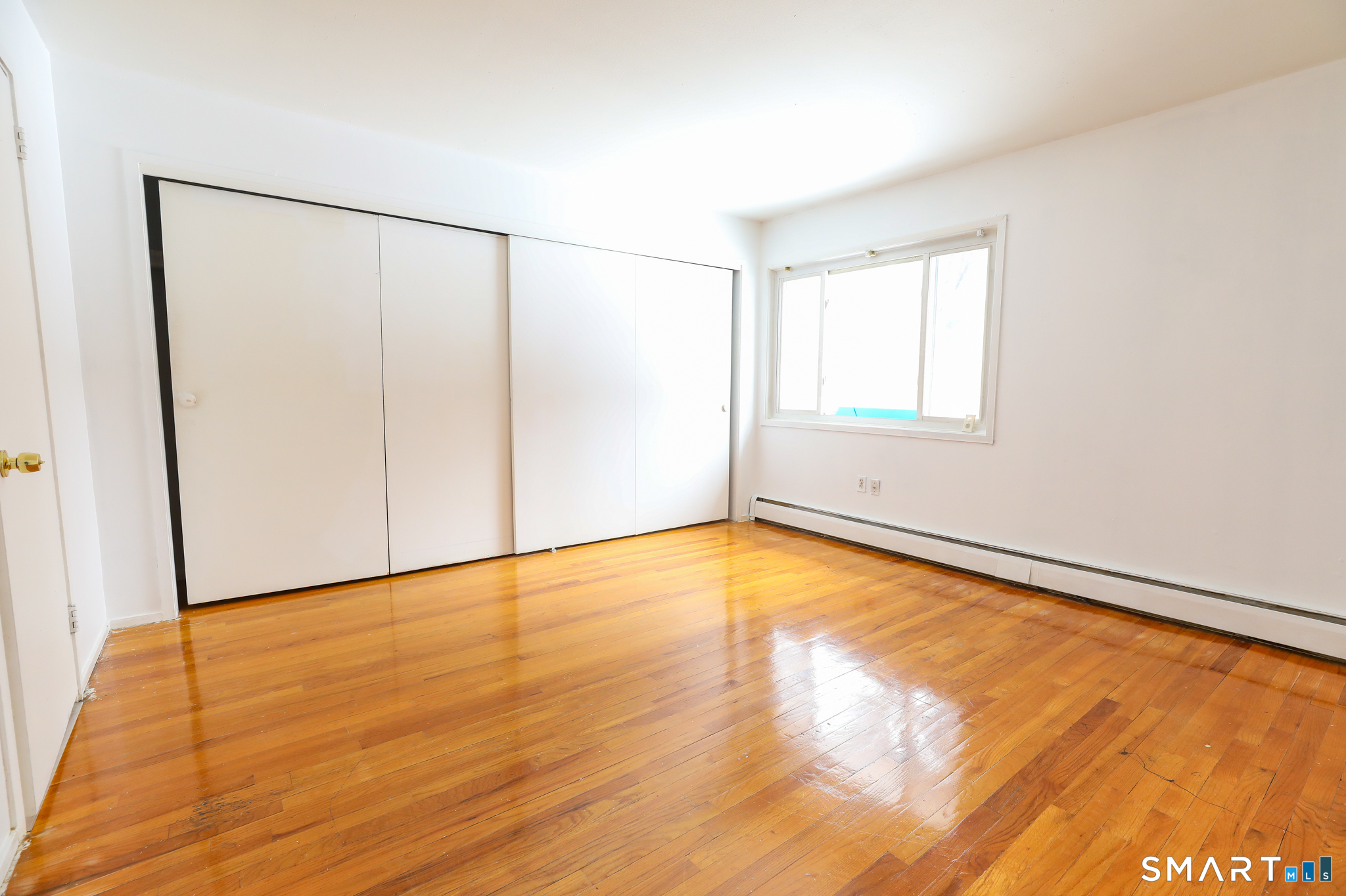 1 Camelot Drive, Unit 2 Bloomfield, CT 06002 - Photo 13 of 24 a view of an empty room with wooden floor and a window