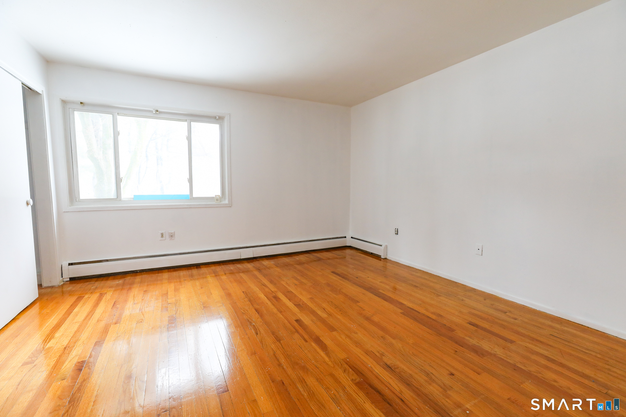 1 Camelot Drive, Unit 2 Bloomfield, CT 06002 - Photo 19 of 24 an empty room with wooden floor and windows