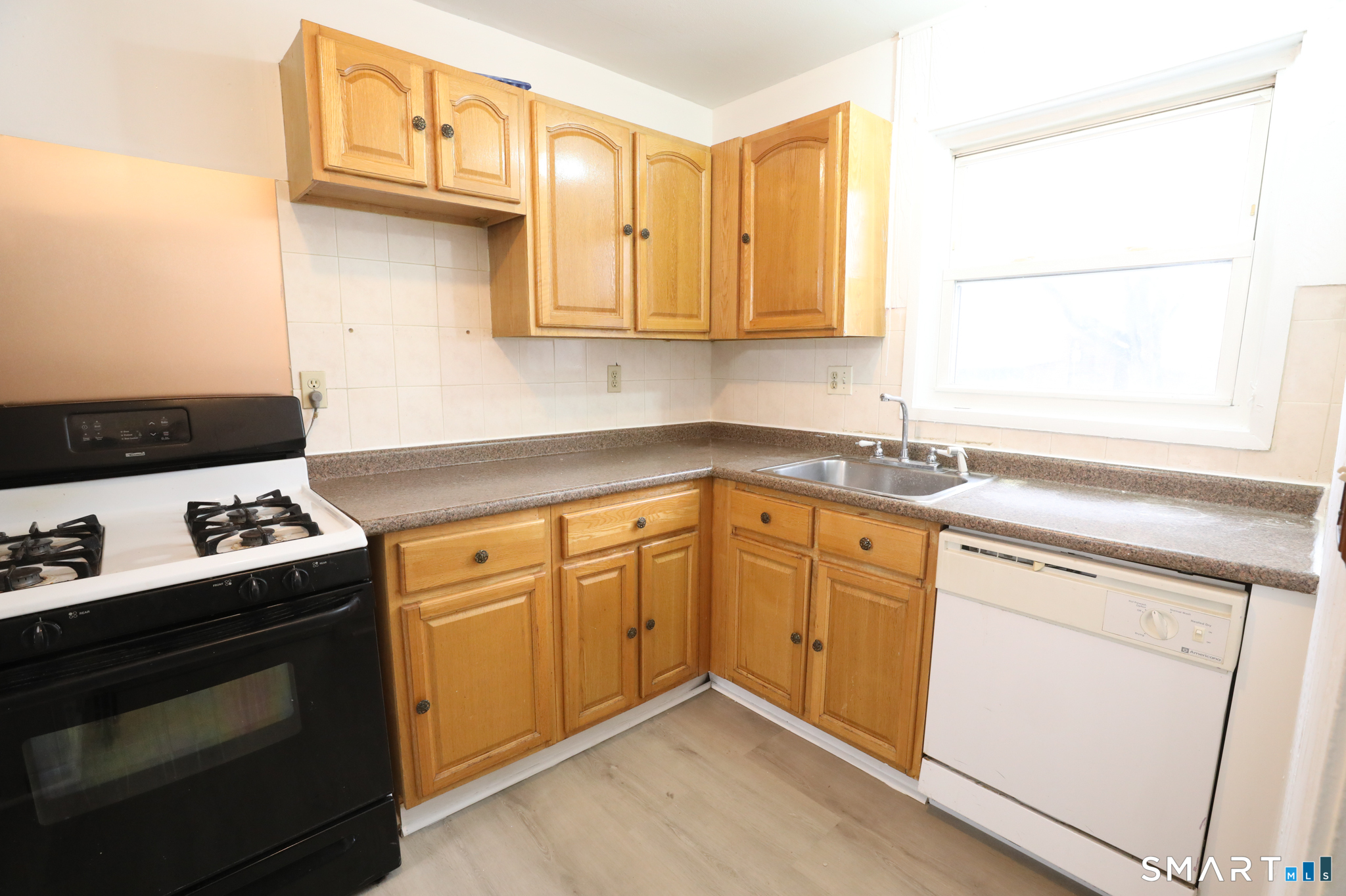1 Camelot Drive, Unit 2 Bloomfield, CT 06002 - Photo 3 of 24 a kitchen with stainless steel appliances granite countertop a sink stove and cabinets