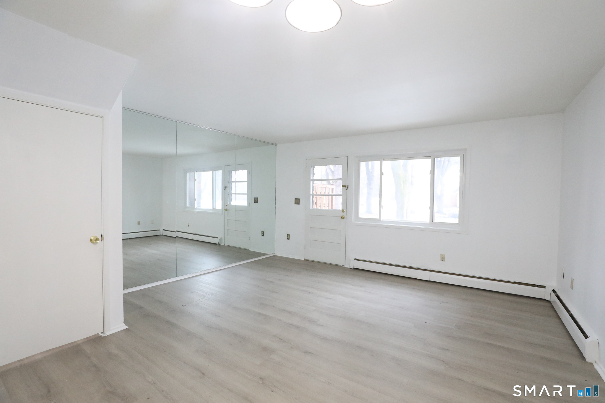 1 Camelot Drive, Unit 2 Bloomfield, CT 06002 - Photo 9 of 24 an empty room with wooden floor and windows