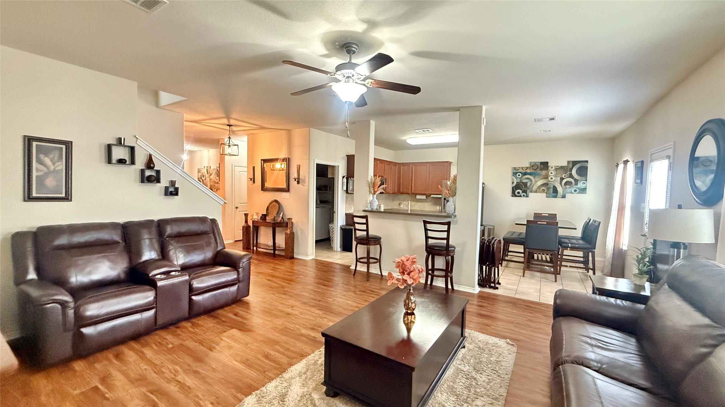 Warm wood flooring flows through a welcoming open layout connecting the main living and dining spaces.