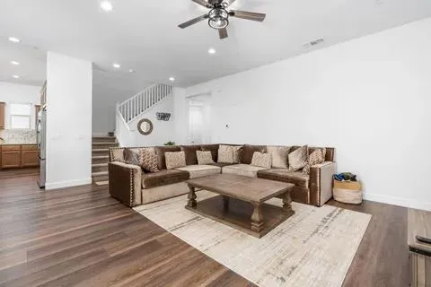 a living room with furniture and a wooden floor