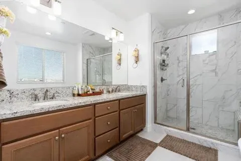a bathroom with a granite countertop sink mirror and shower
